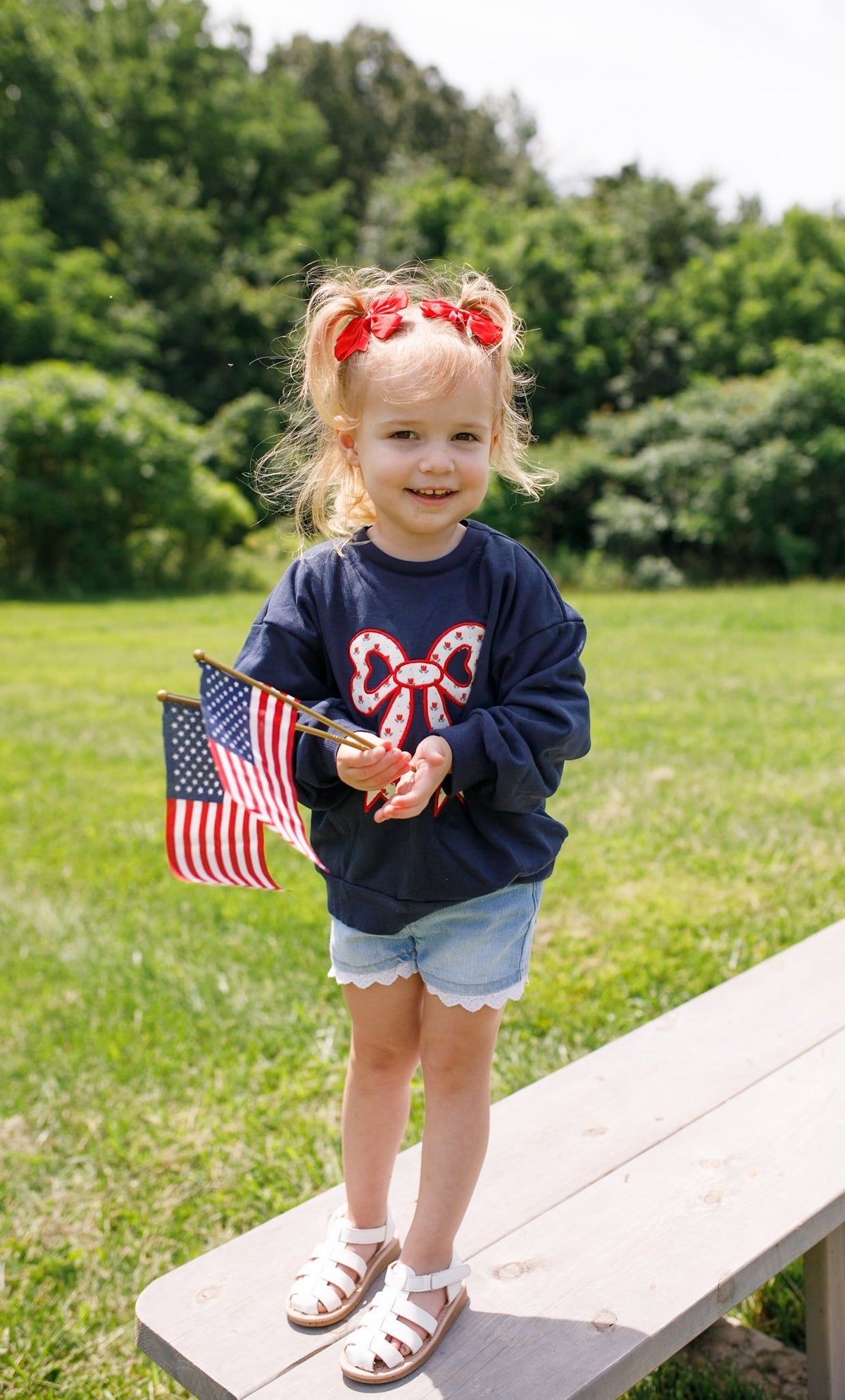 Toddler Little Joy Co. organic cotton sweatshirt with tulip print and embroidered bow applique.