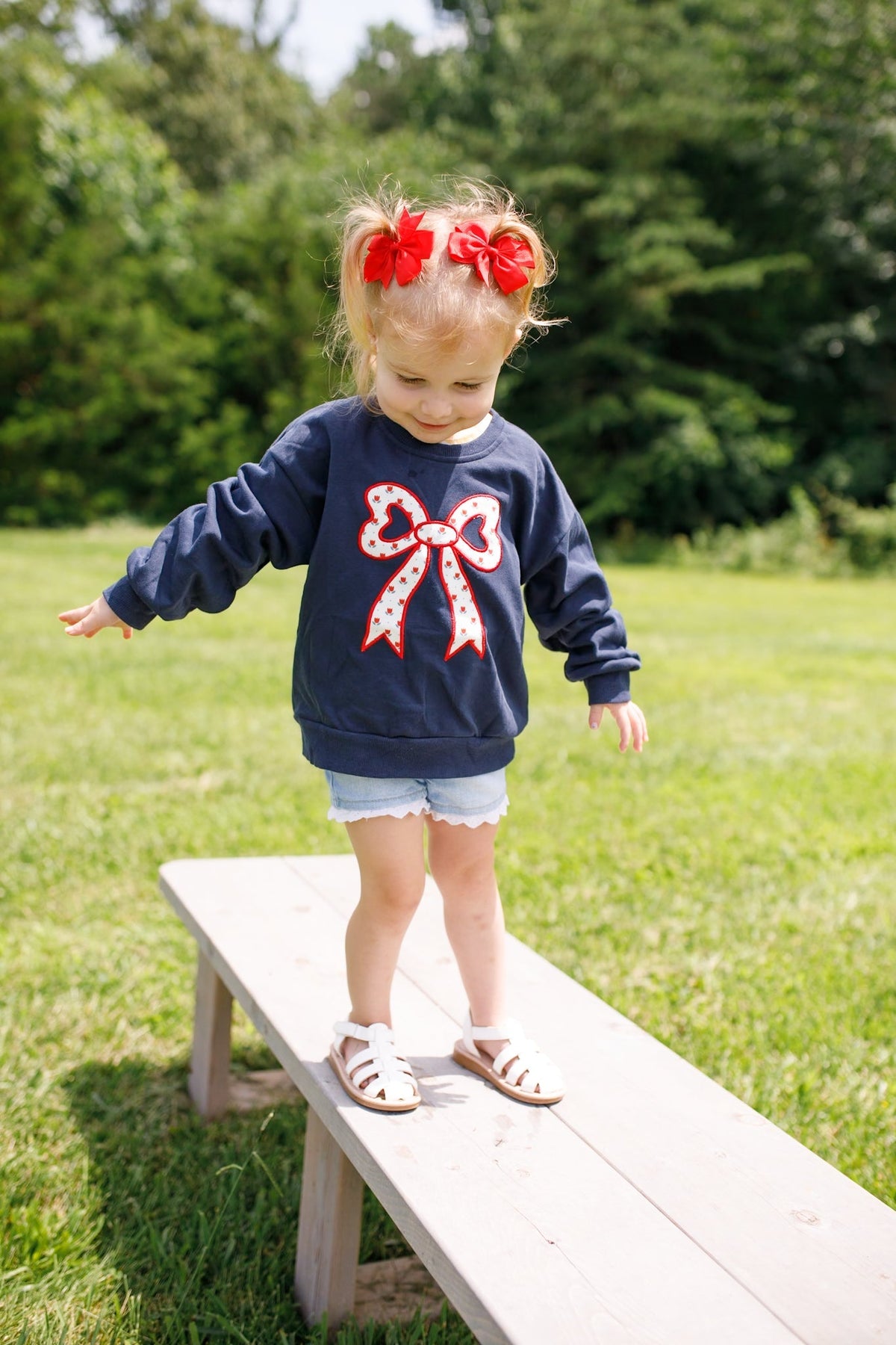 Toddler Little Joy Co. organic cotton sweatshirt with tulip print and embroidered bow applique.