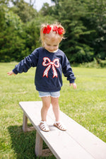Toddler Little Joy Co. organic cotton sweatshirt with tulip print and embroidered bow applique.