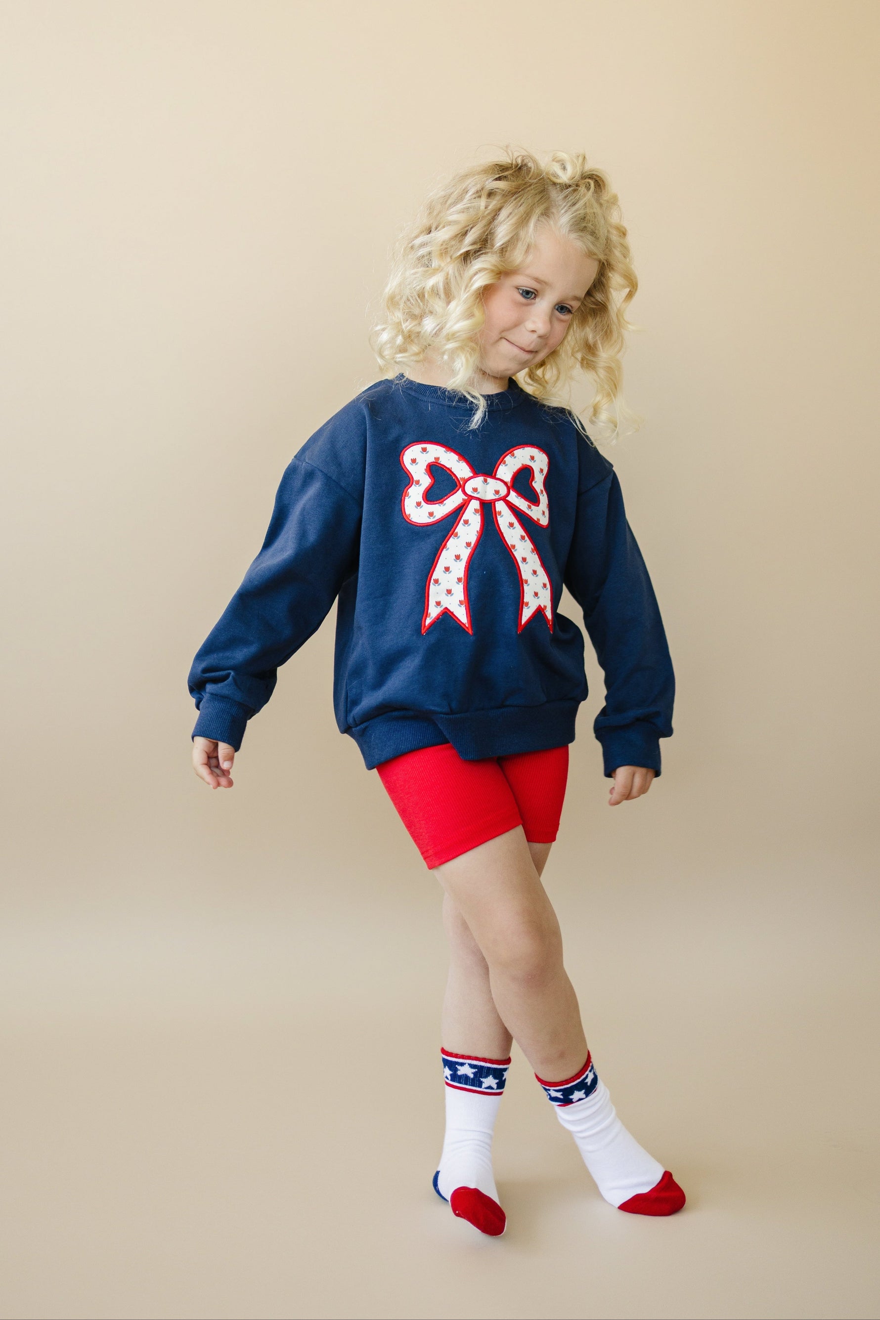 Toddler Little Joy Co. organic cotton sweatshirt with tulip print and embroidered bow applique.