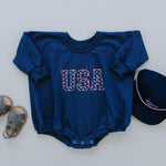 Little Joy Co. organic terry sweatshirt romper for babies, light gray, shown on a happy baby.