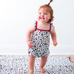 Bubble romper with flutter sleeves in a pink groovy floral print, with snaps along the legs.