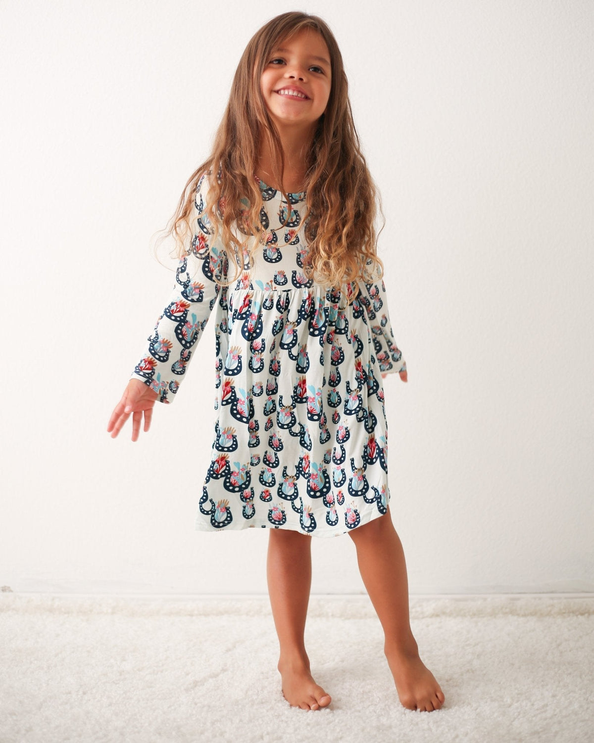 Long-sleeve toddler dress with a floral blossom print, shown on a child model