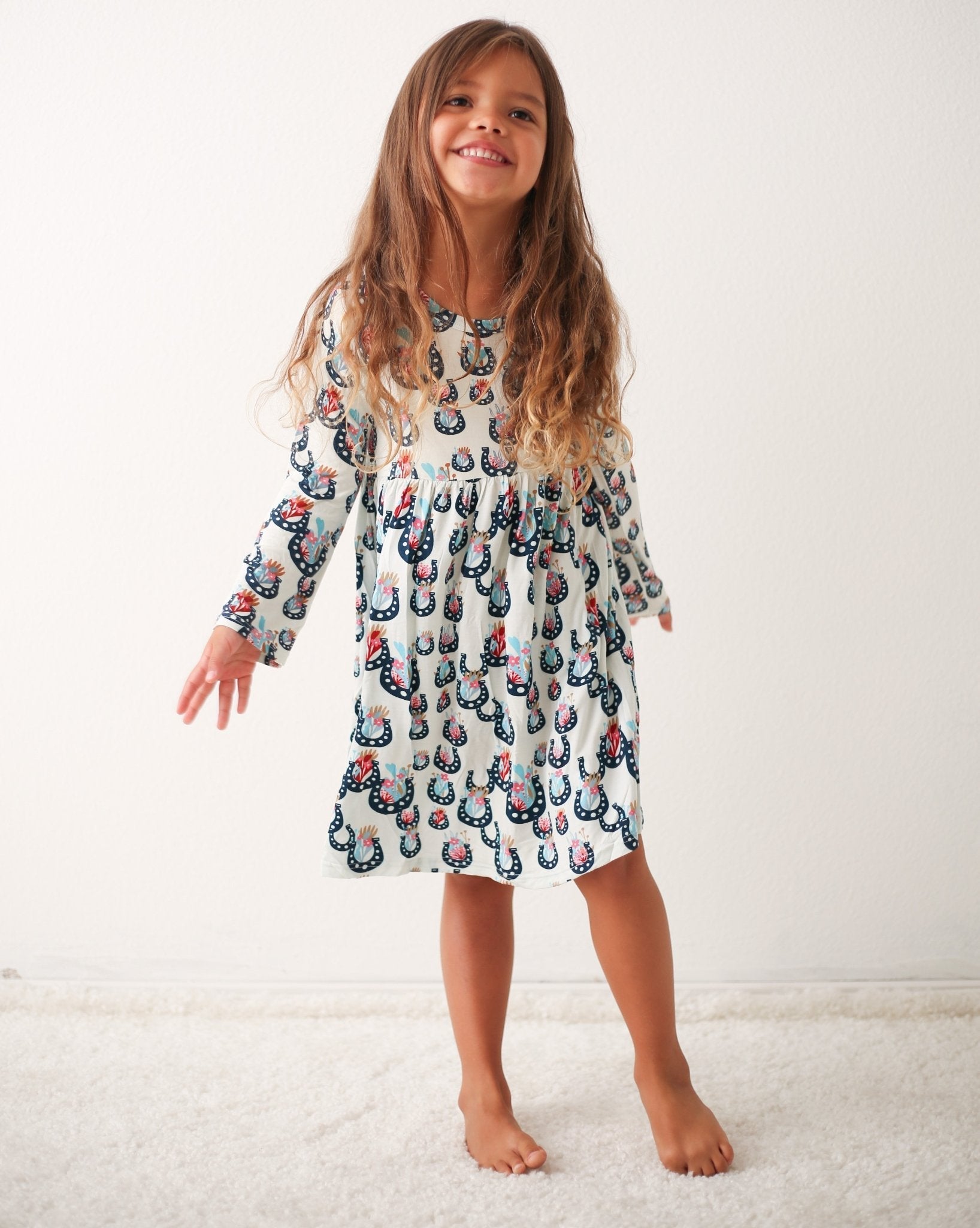 Long-sleeve toddler dress with a floral blossom print, shown on a child model