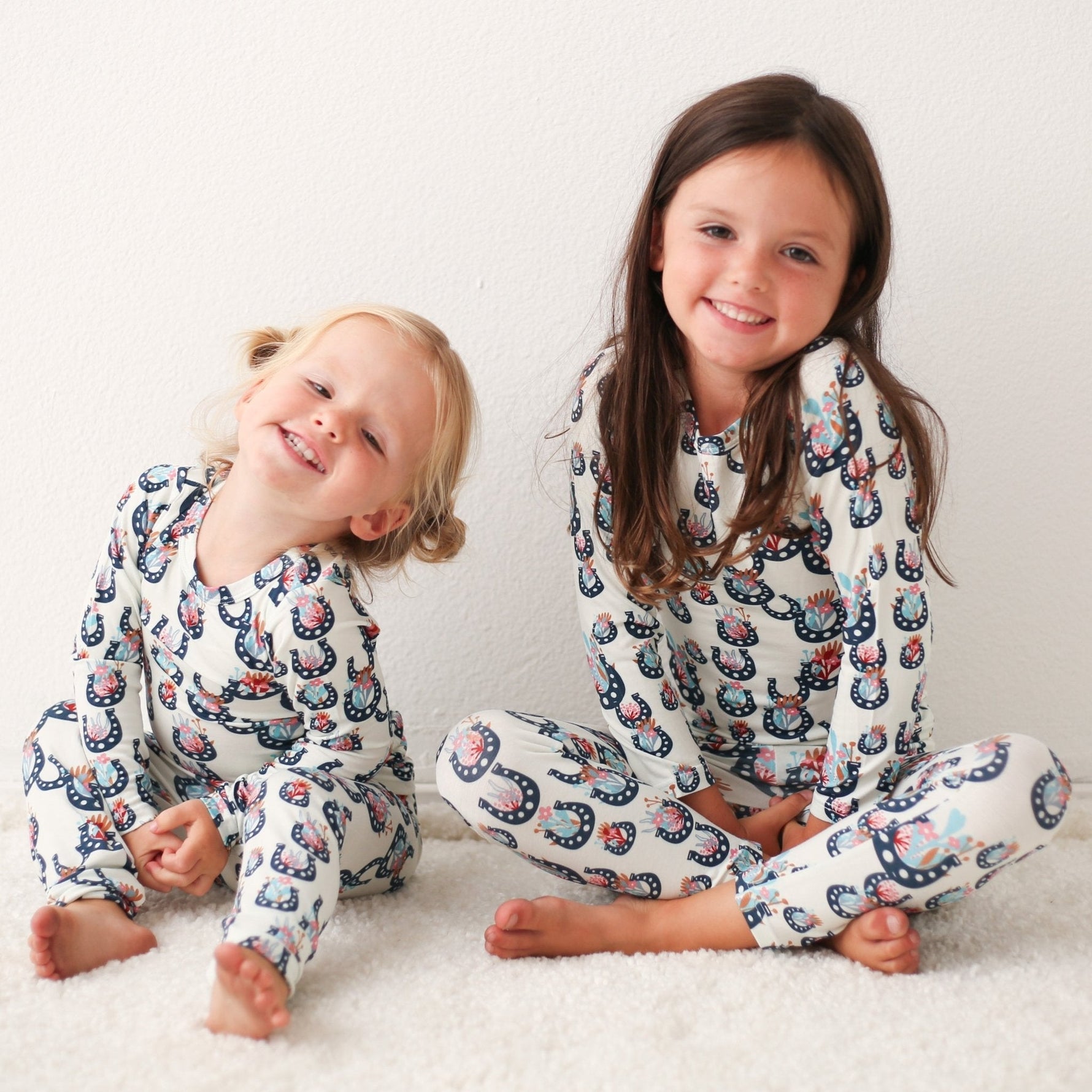 Two-piece baby pajamas with a floral print top and matching pants on a child model.