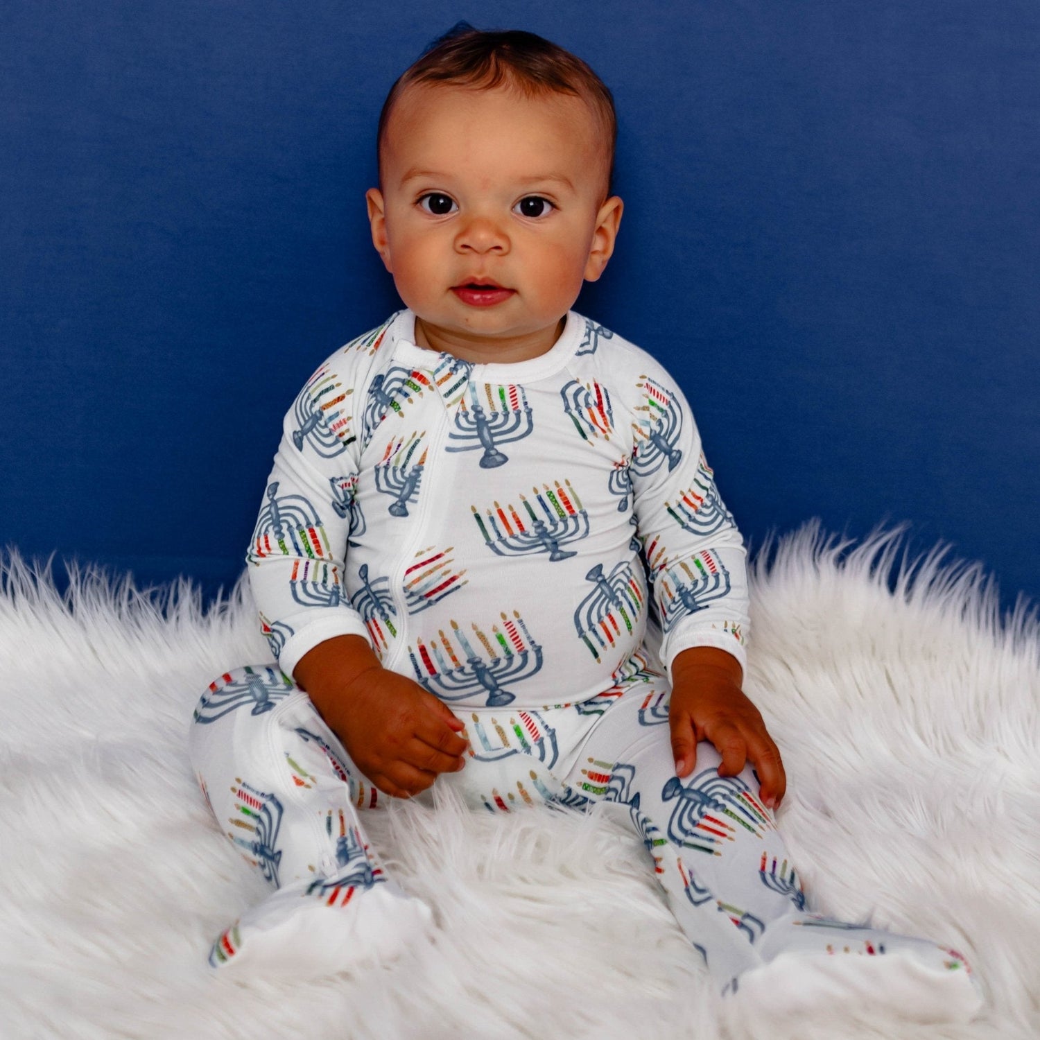 Baby footie pajamas with an allover Hanukkah menorah print, dual zipper front, and fold-over hand mittens.