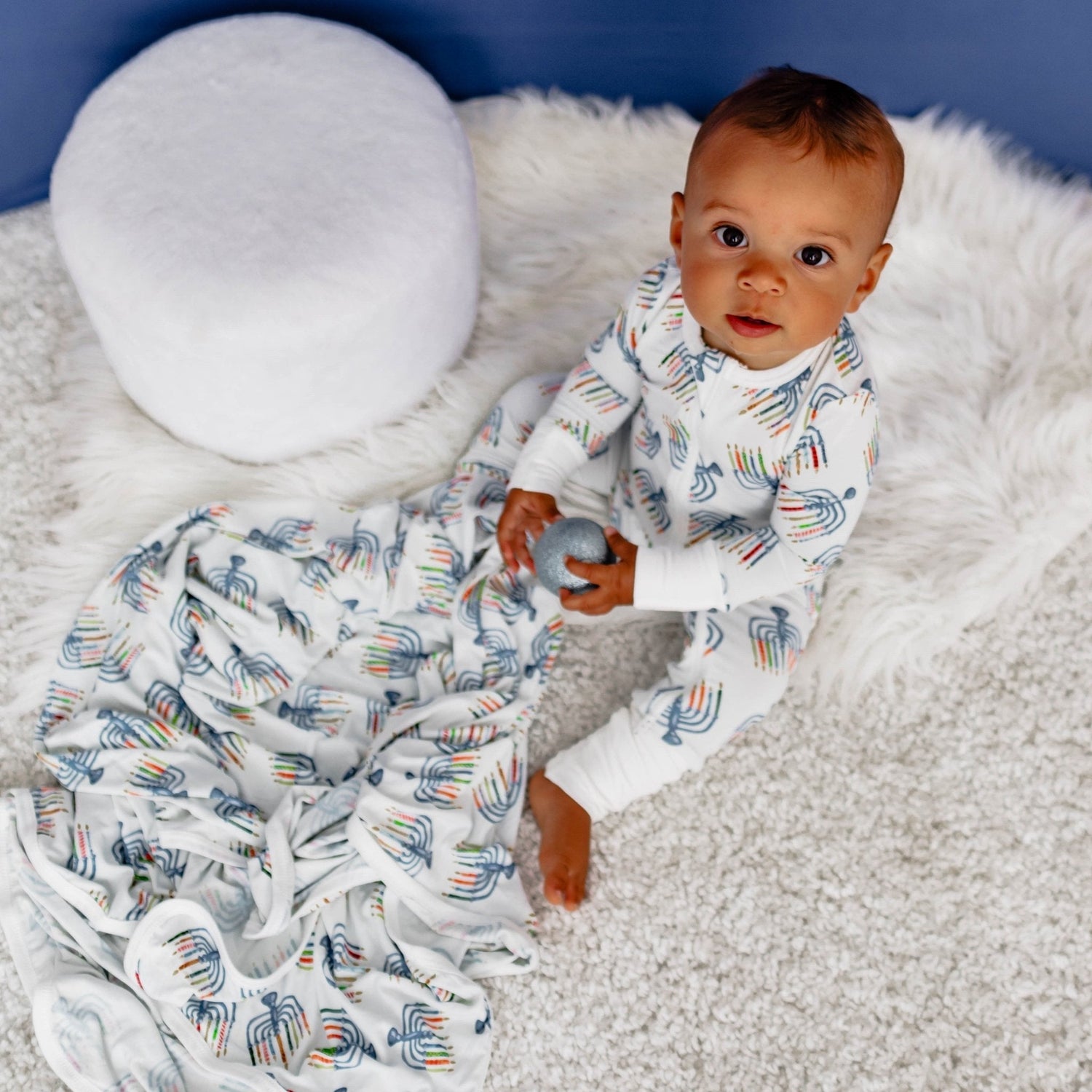 Convertible coverall with a Hanukkah menorah print, shown with footed legs and a full-length front zipper.