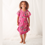 Hot pink dress with painted floral pattern and lace trim at the arms, worn by a child with sandals.