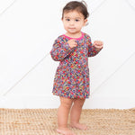 Long-sleeve bodysuit dress with a dark floral petal print, worn by a toddler