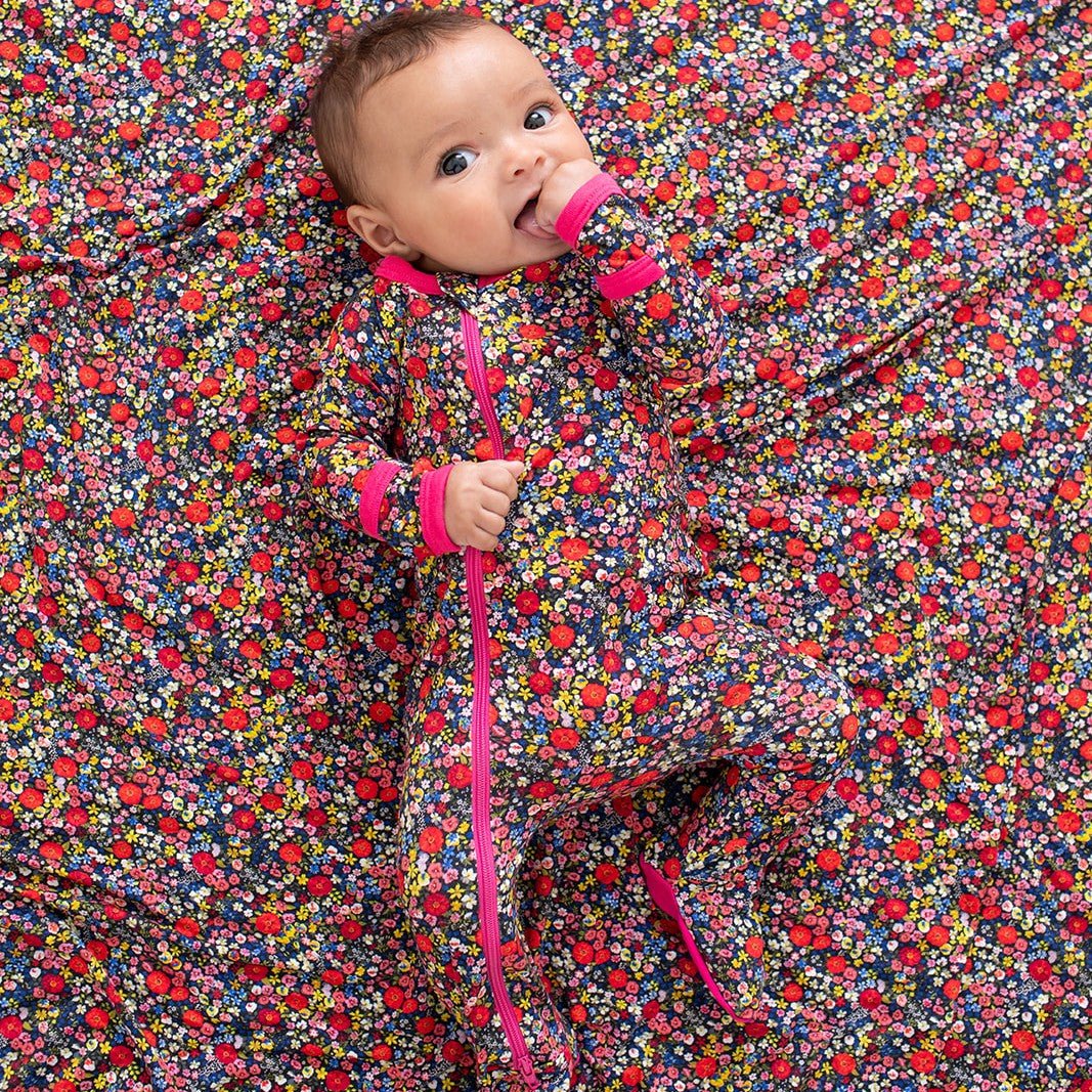 Footie sleeper in a dark midnight floral petal print with a full-length front zipper and covered feet
