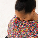 Nursing cover in dark midnight floral print with a round neckline, shown with matching zippered pouch.