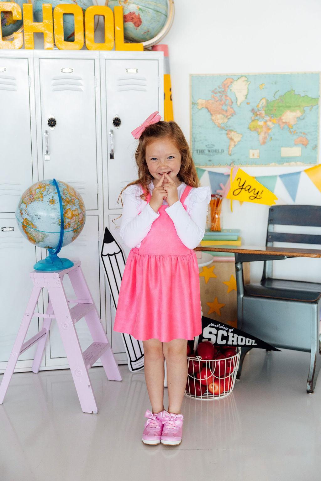 Neon pink faux suede pinafore dress with crisscross adjustable straps in the back