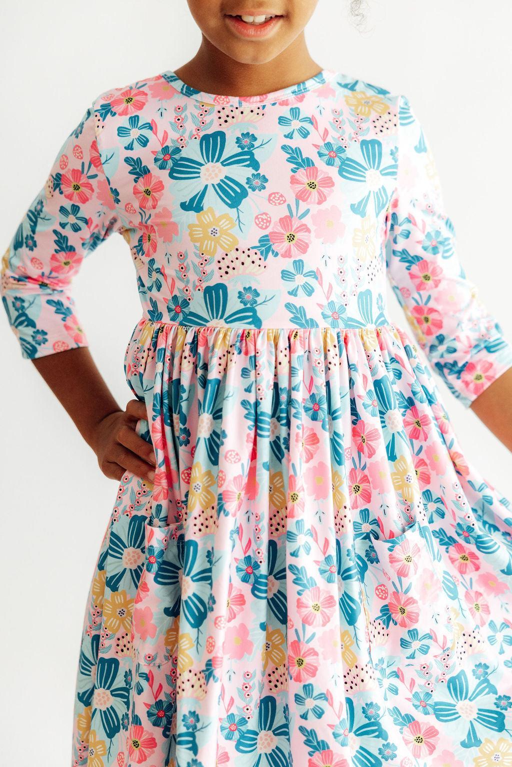 Floral garden print twirl dress with 3/4 sleeves and side pockets in a full, twirling skirt.