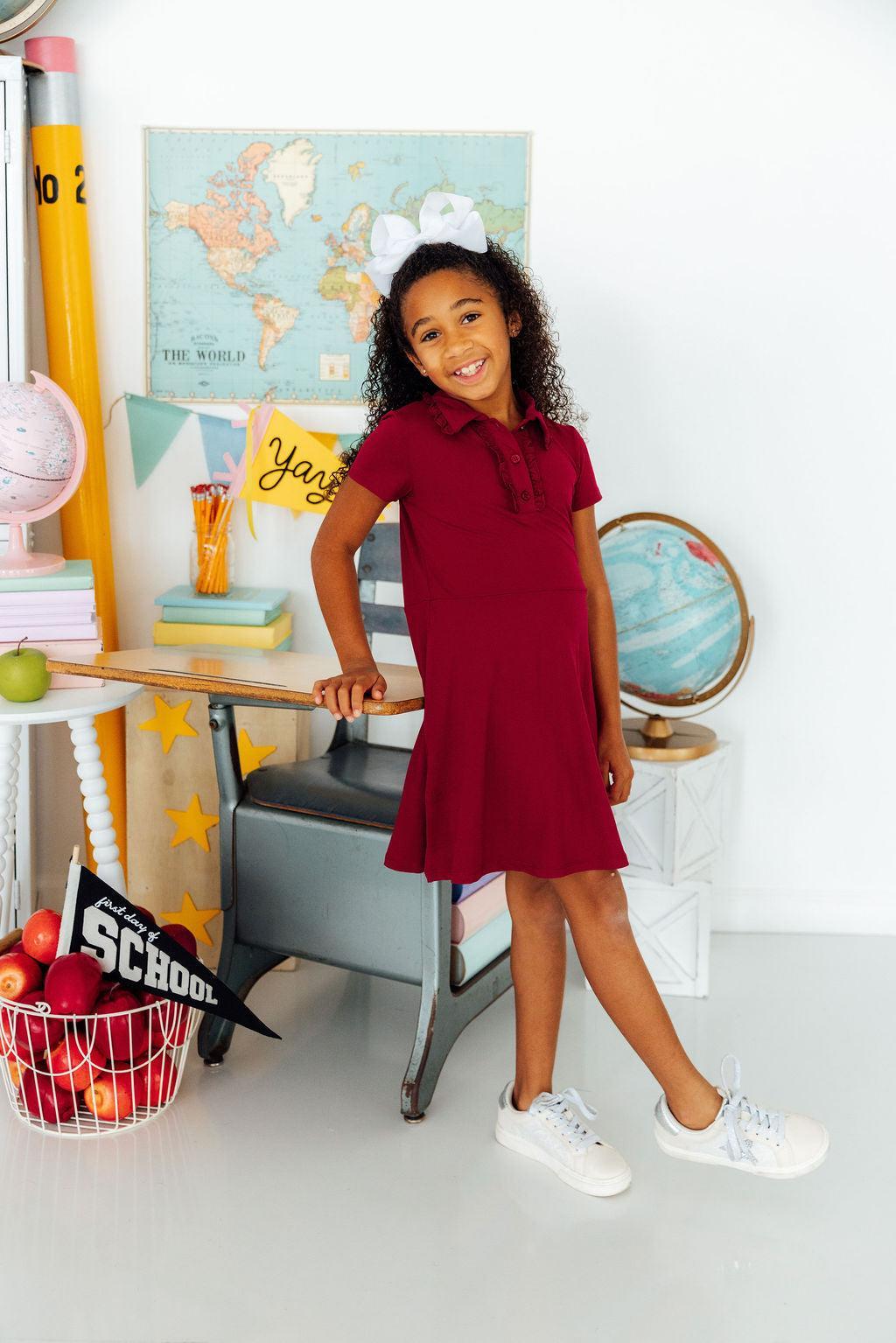 Burgundy short-sleeve polo dress with ruffled collar, button placket, and A-line twirl skirt