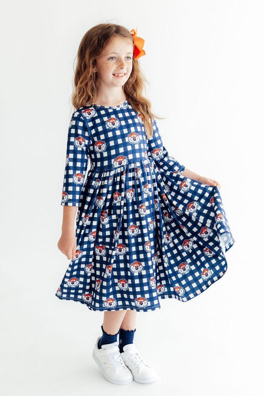 Auburn plaid twirl dress with 3/4 sleeves and side pockets in orange and navy check