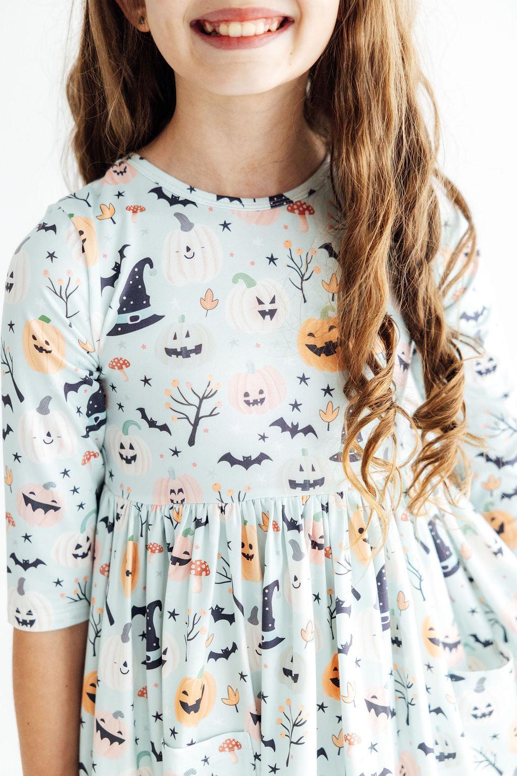 Girls' 3/4 sleeve twirl dress in a Ghouls Rule Halloween print with side pockets and full twirl skirt