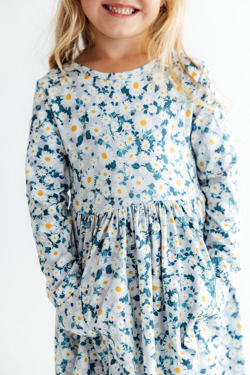 Long sleeve twirl dress in a daisy print with pockets and a full, twirl-ready skirt