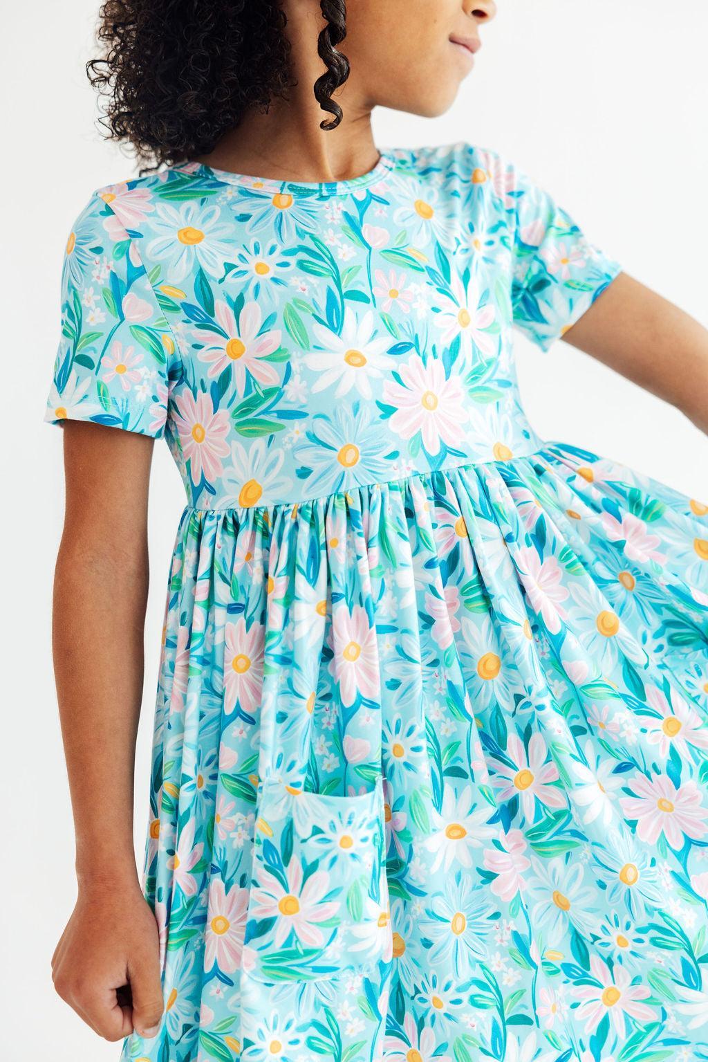 Short-sleeve twirl dress in a preppy daisy print with pockets and a full twirly skirt.