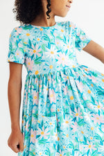 Short-sleeve twirl dress in a preppy daisy print with pockets and a full twirly skirt.