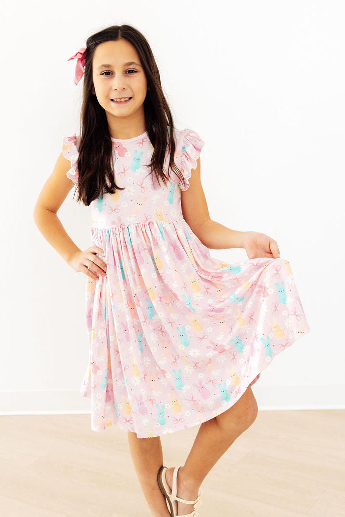 Toddler girl smiling and twirling in a Mila & Rose Preppy Peeps Flutter Sleeve Dress.