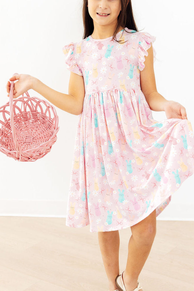 Toddler girl smiling and twirling in a Mila & Rose Preppy Peeps Flutter Sleeve Dress.