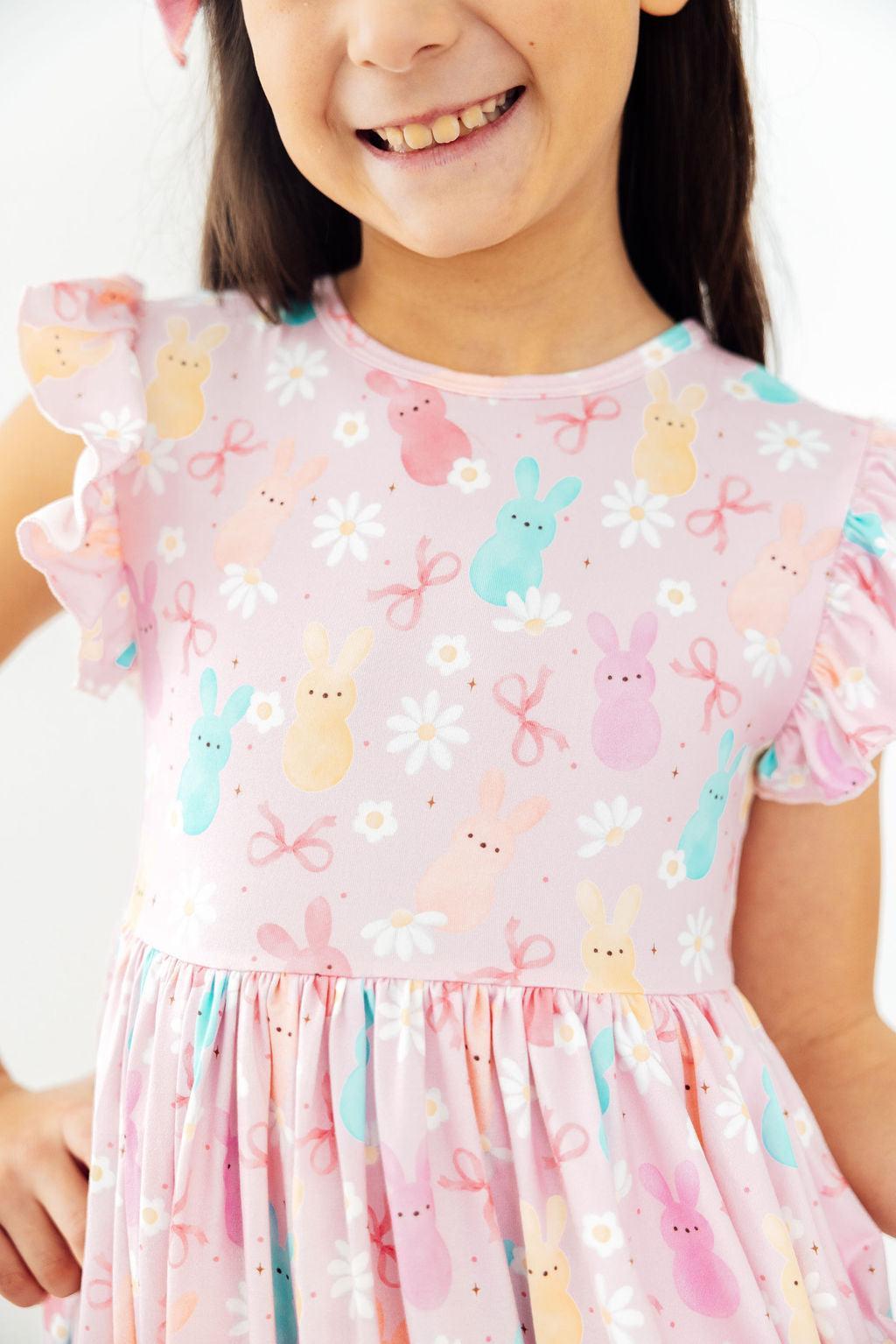 Toddler girl smiling and twirling in a Mila & Rose Preppy Peeps Flutter Sleeve Dress.