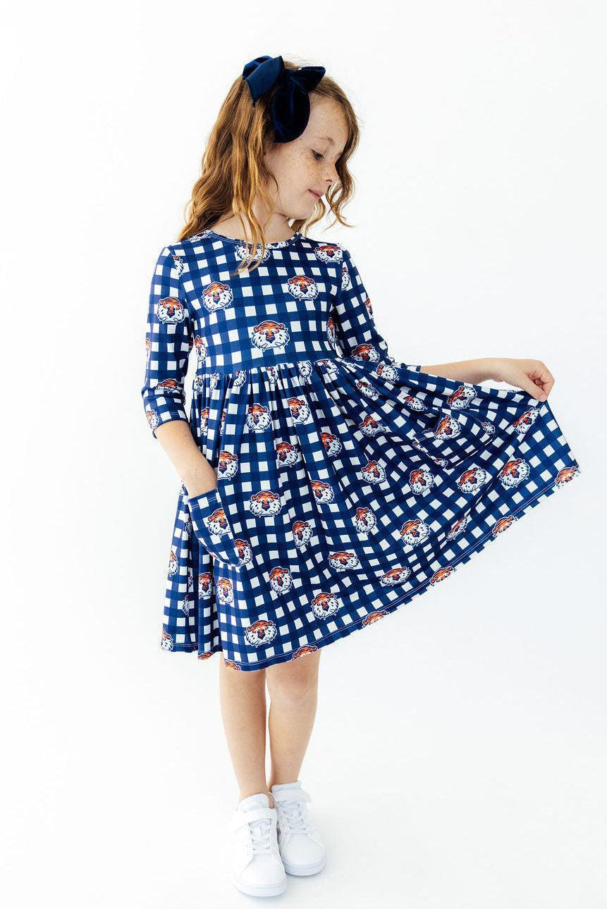 Plaid twirl dress with 3/4 sleeves and front pockets, full skirt shown spread out