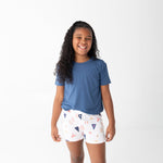 Girls shorts set with a solid blue short-sleeve top and shorts printed with sailboats, lobsters, and lighthouses.
