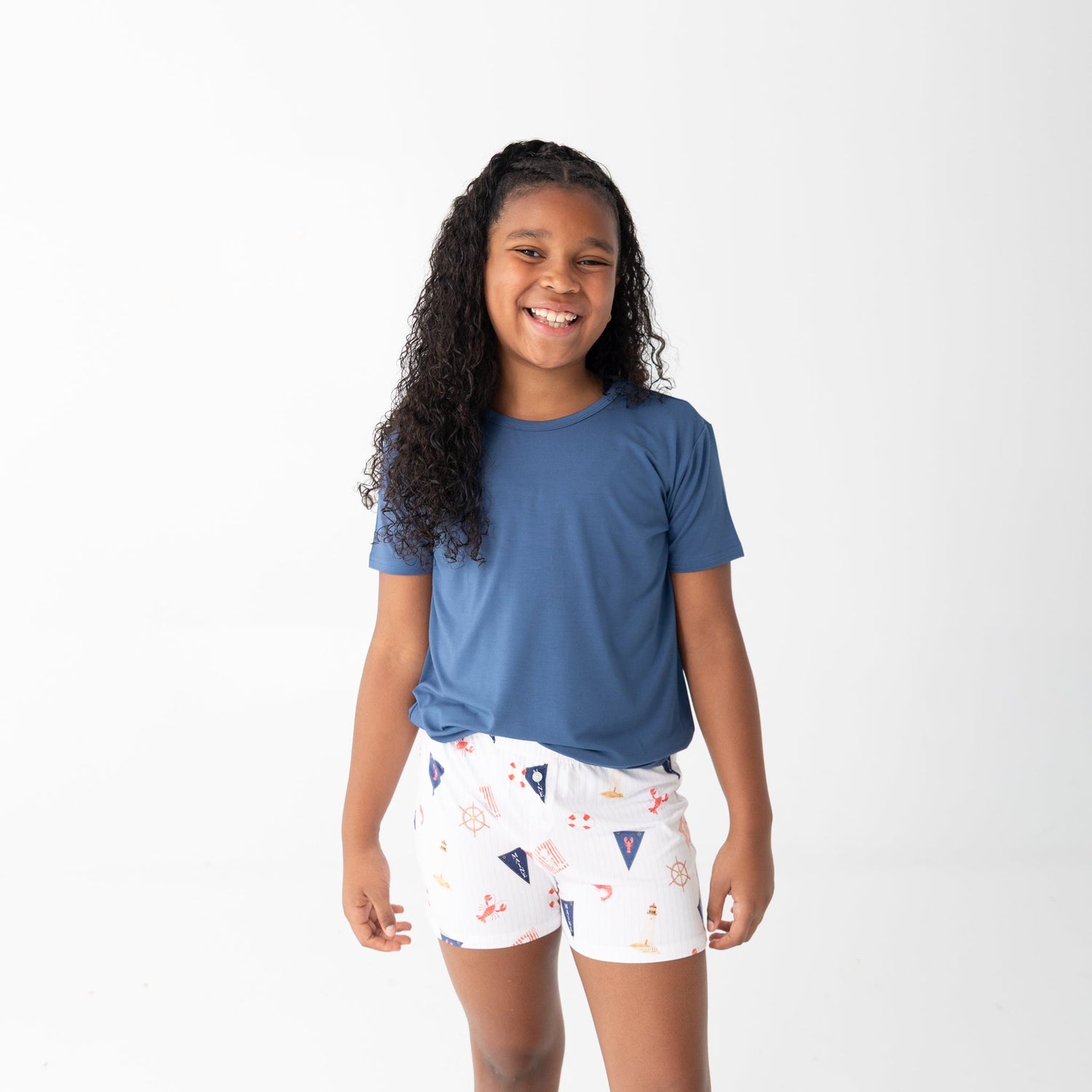 Girls shorts set with a solid blue short-sleeve top and shorts printed with sailboats, lobsters, and lighthouses.