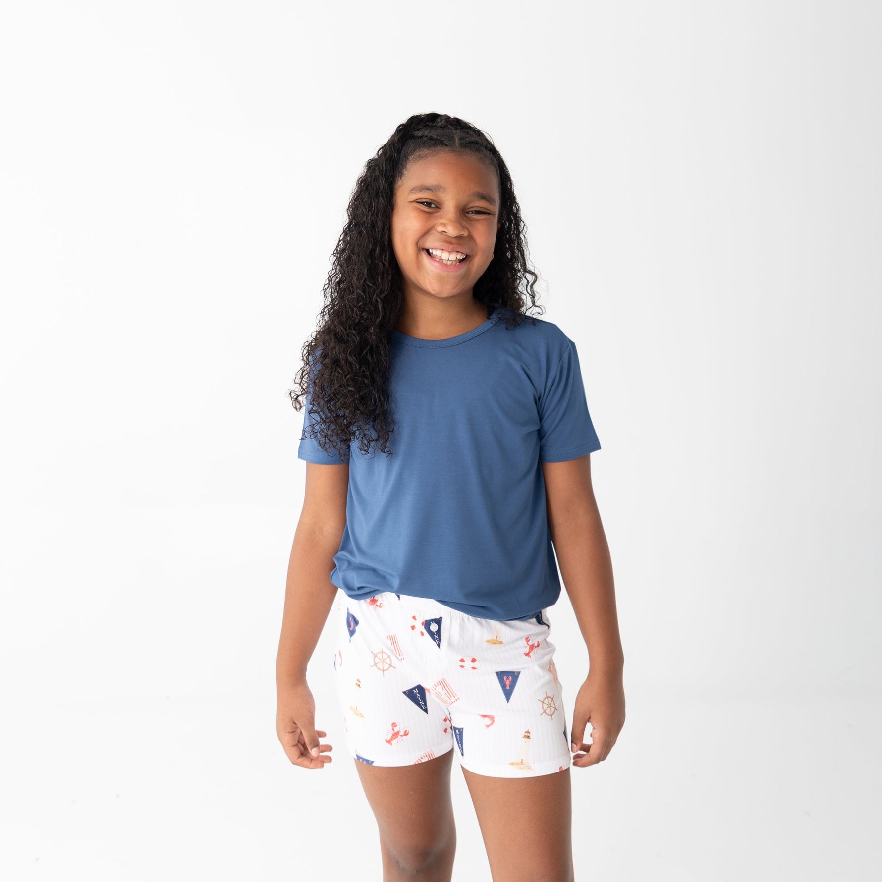 Girls shorts set with a solid blue short-sleeve top and shorts printed with sailboats, lobsters, and lighthouses.