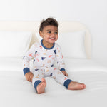 Toddler two-piece pajamas in a nautical print with sailboats, lighthouses, lobster flags, and ship wheels