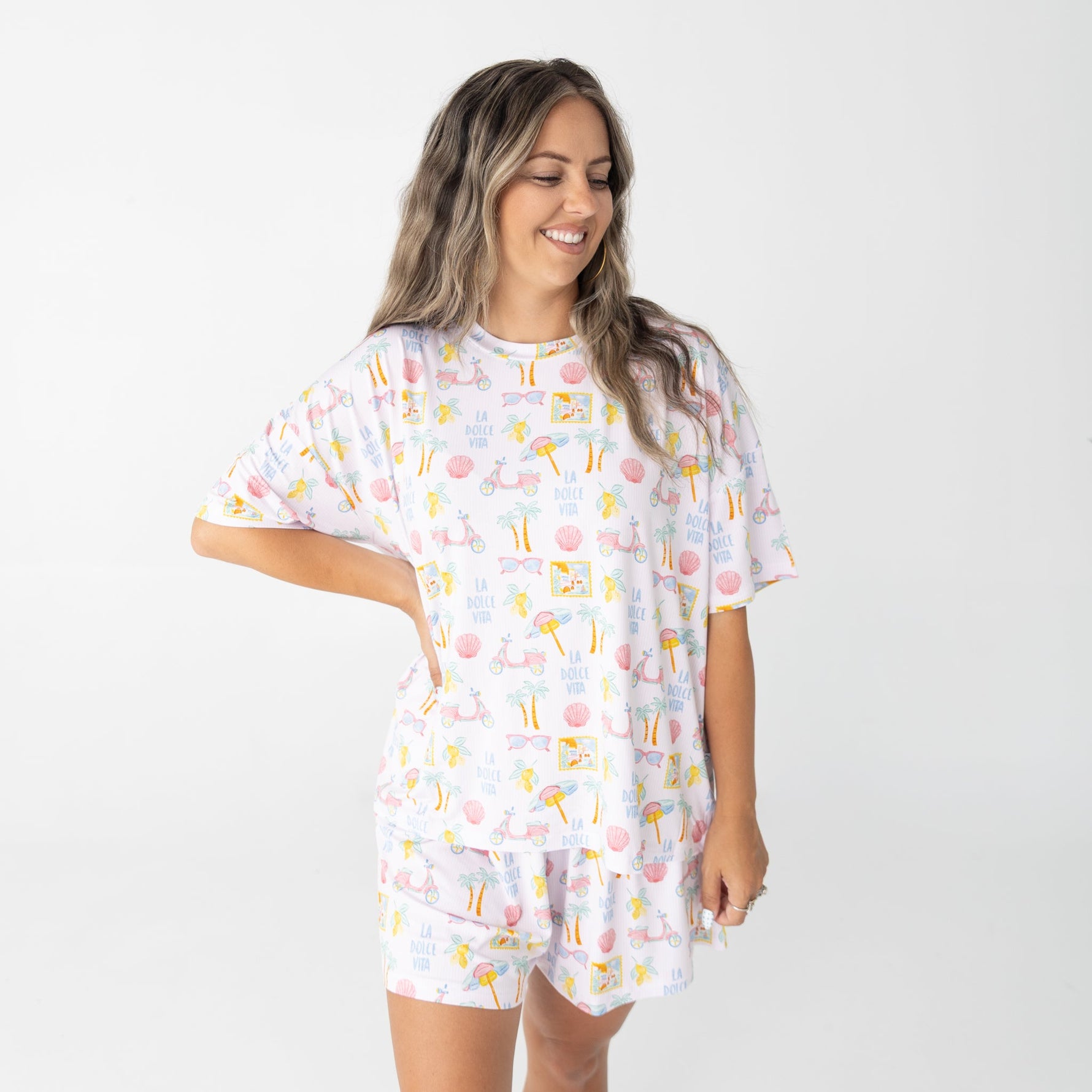 Women's short sleeve top and shorts set with pink scooters, lemons, palm trees, and postcard details