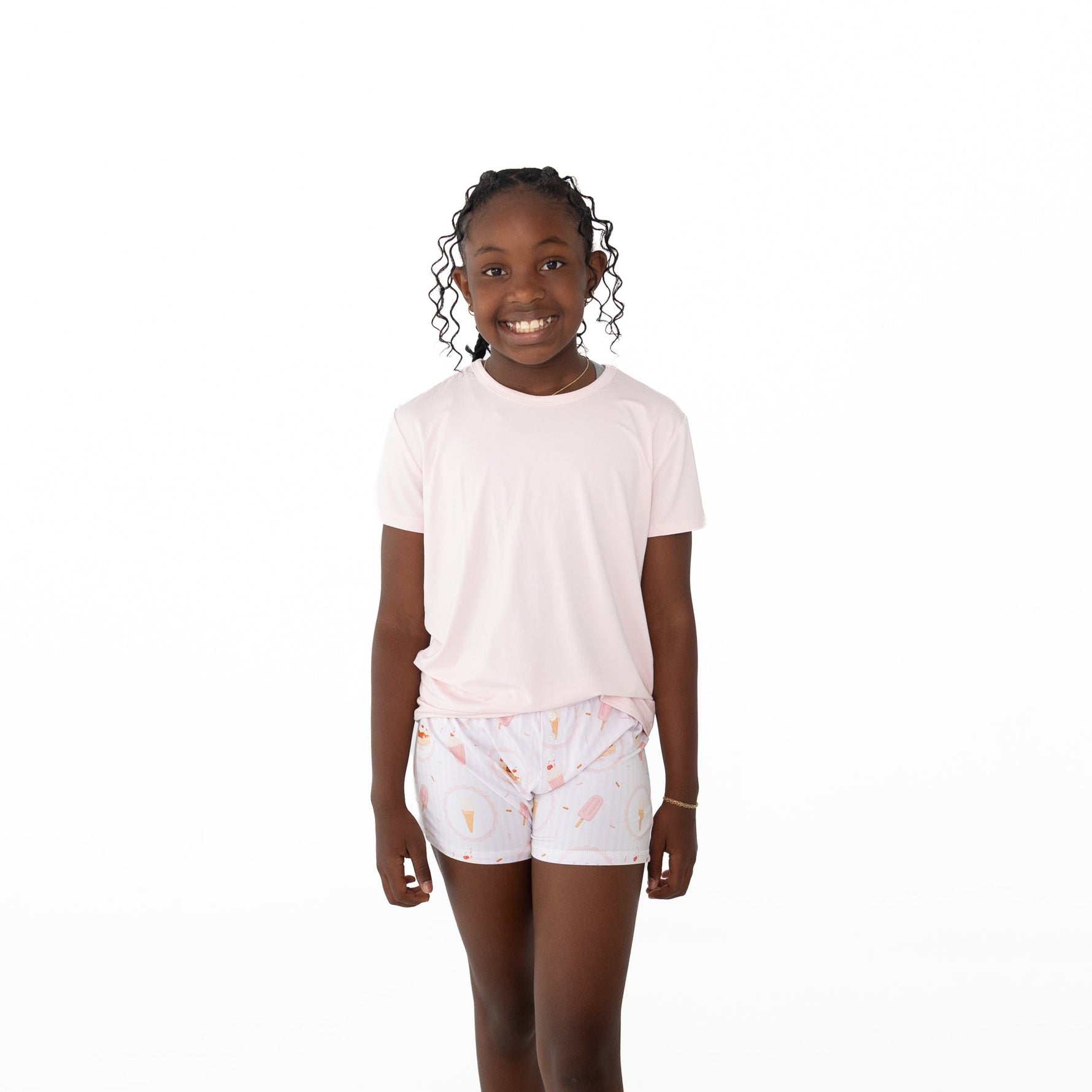 Girls shorts set with a solid pink short sleeve top and shorts printed with ice cream cones, popsicles, and sprinkles on