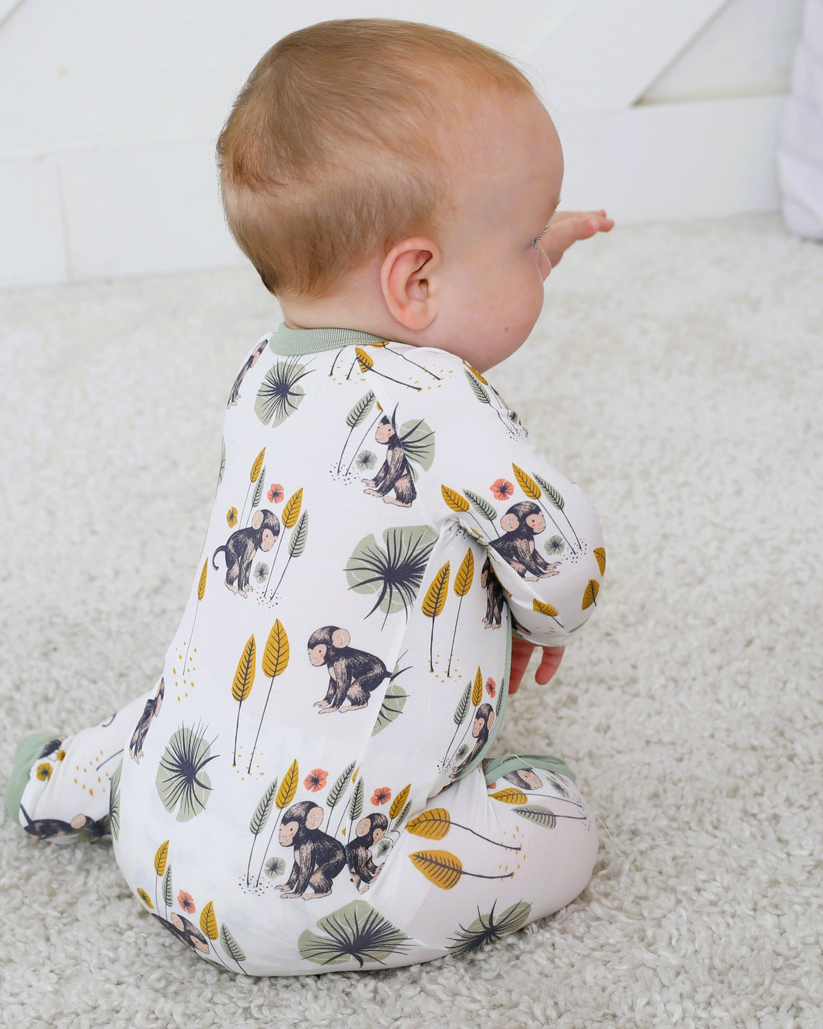 Baby footie pajamas in a monkey print with a full-length two-way zipper and covered feet