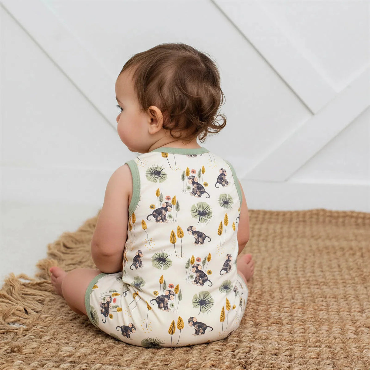 Sleeveless baby shortall in a monkey print with snap closures at the shoulders and legs