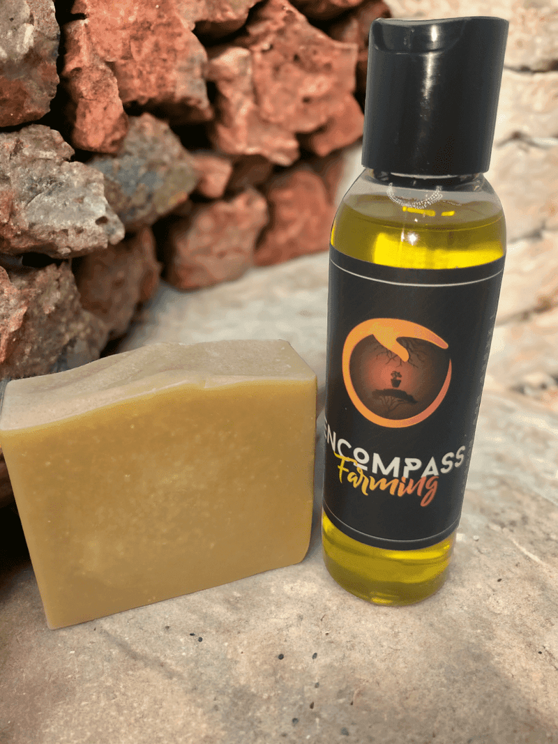 Natural goat milk soap and Encompass oil bottle on stone background.