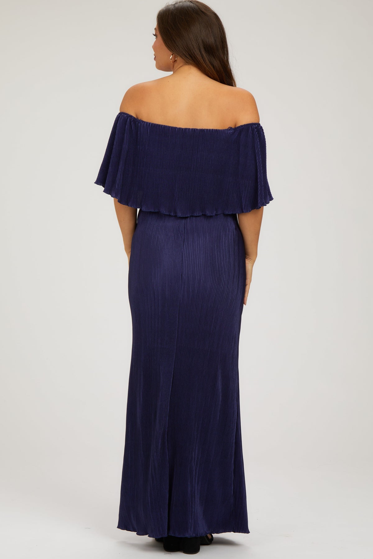 Model wearing a navy pleated ruffle off-shoulder maternity maxi dress by PinkBlush, smiling.