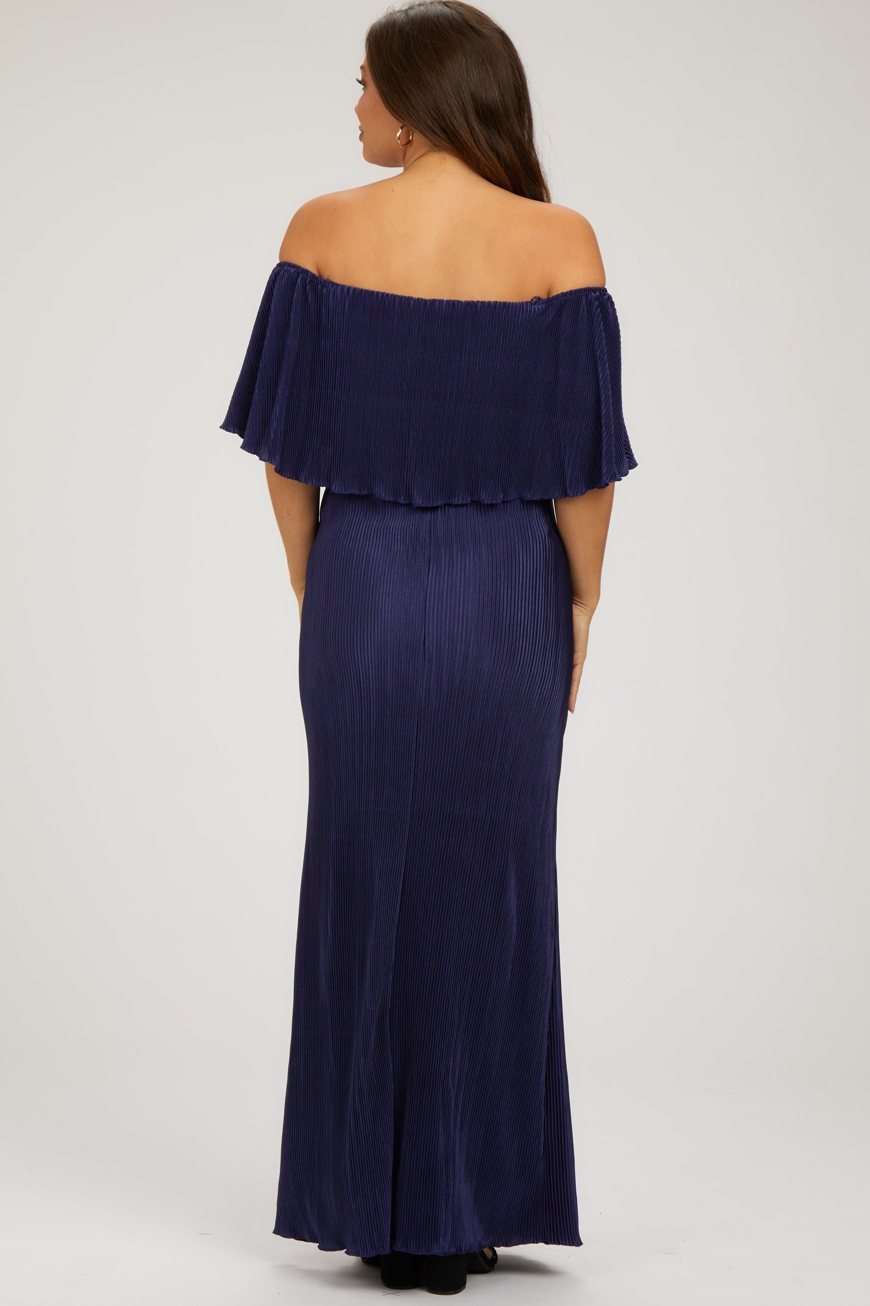 Model wearing a navy pleated ruffle off-shoulder maternity maxi dress by PinkBlush, smiling.