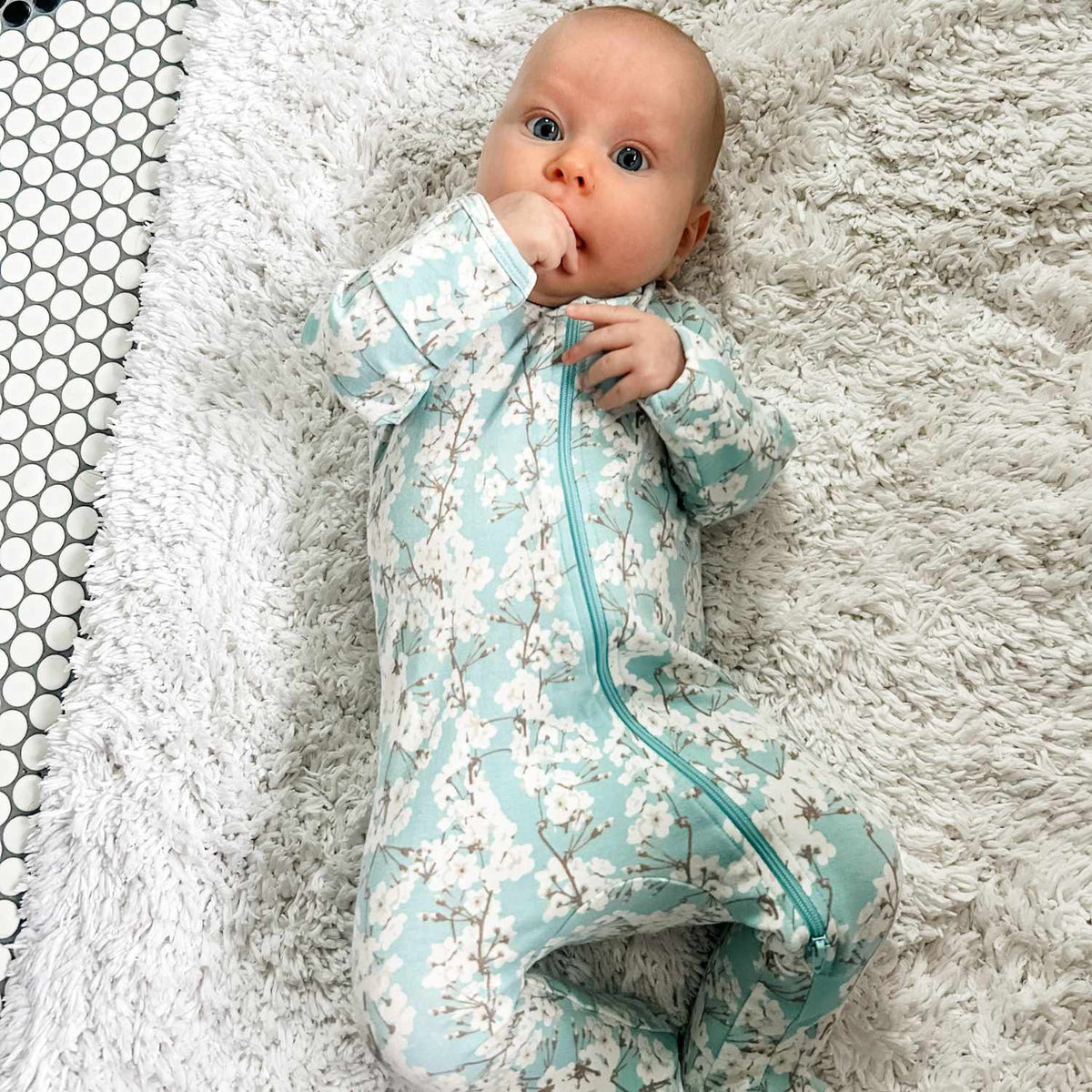 Norani Baby newborn organic footed onesie with contrast zipper.