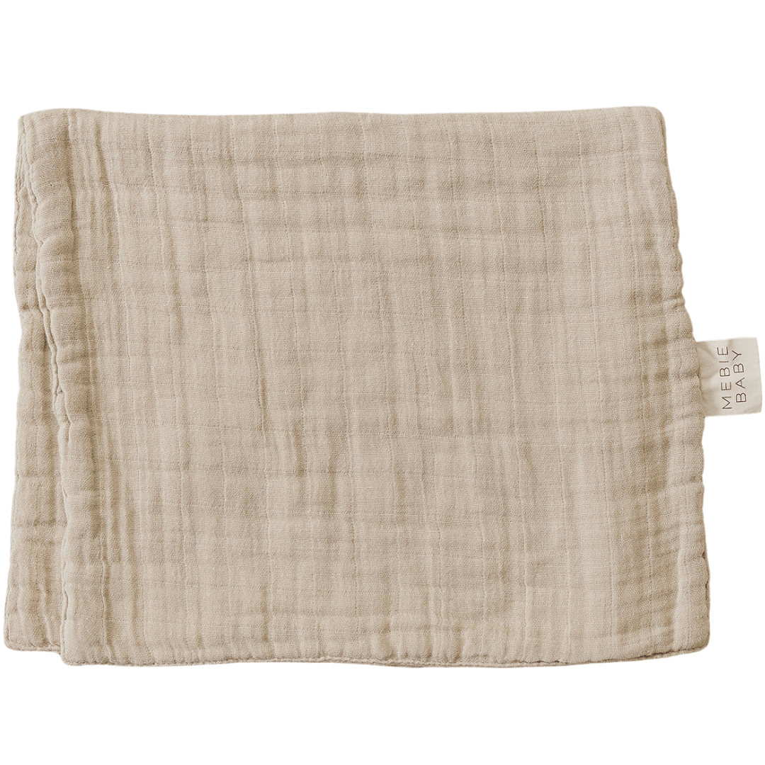 Oatmeal-colored muslin burp cloth in a solid neutral tan shade, laid flat