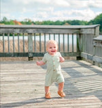 Short sleeve baby romper with front buttons and a relaxed fit, shown as a one-piece garment.