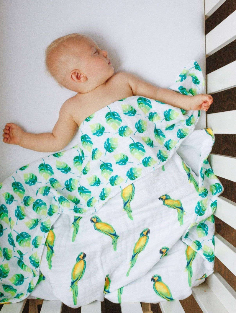 Baby wrapped in Parrots Organic Snug Blanket with watercolor print.