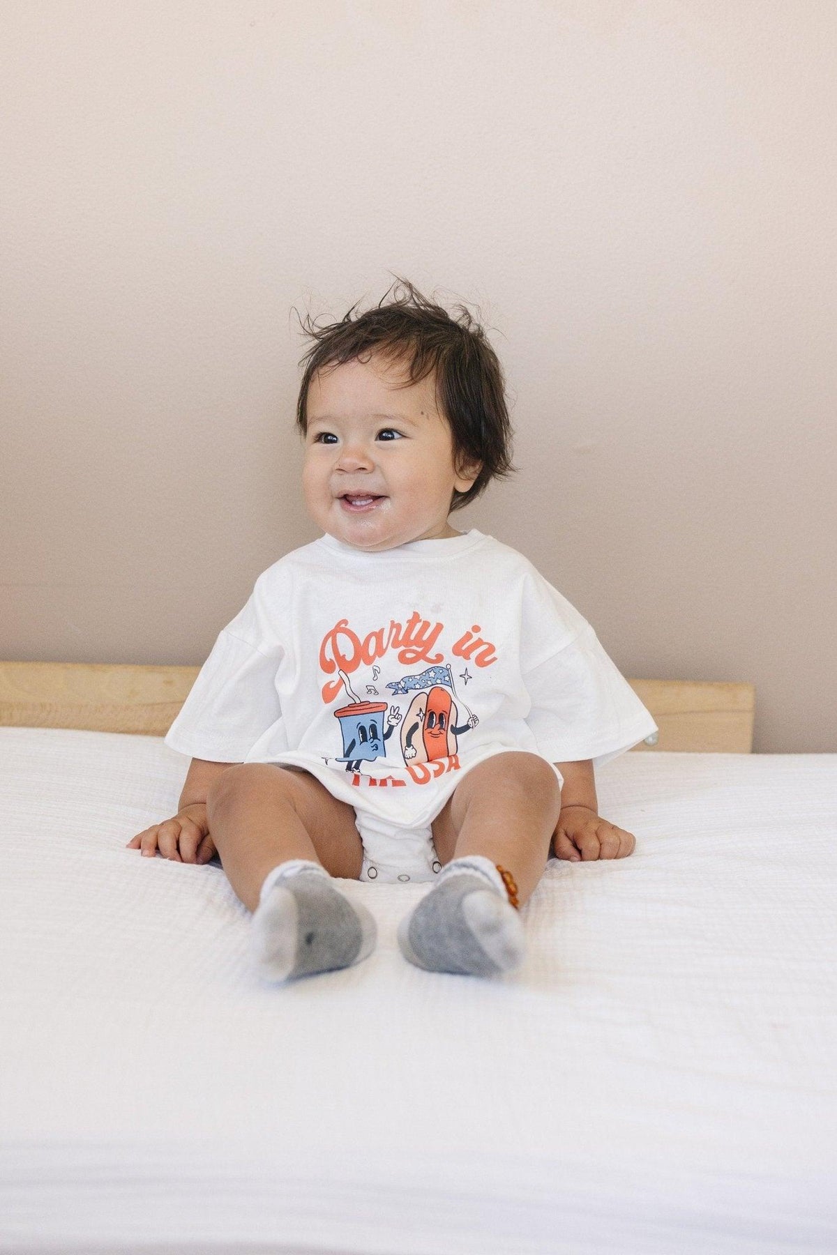 Little Joy Co. organic baby t-shirt romper with 'Party in the USA' graphic, front view