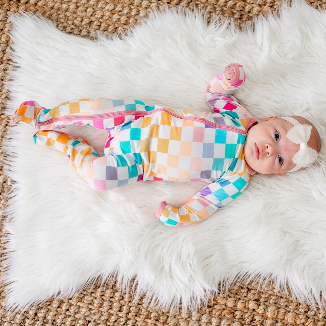 Baby footie pajamas in a pastel checkered print with a full-length zipper and covered feet.