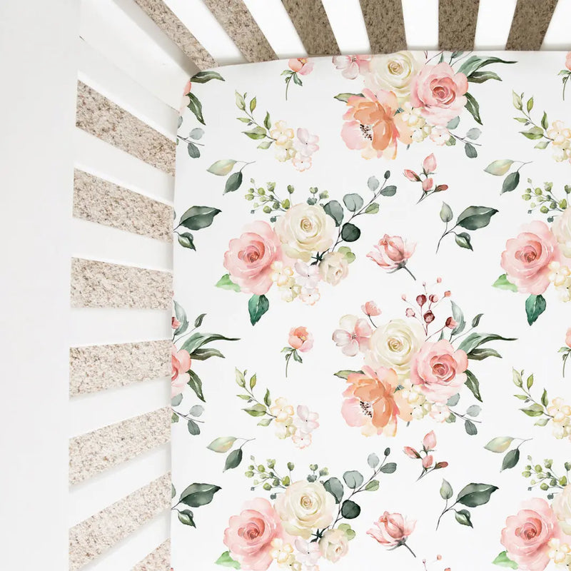 Peach floral fitted crib sheet with soft fabric and unique pattern in a crib.
