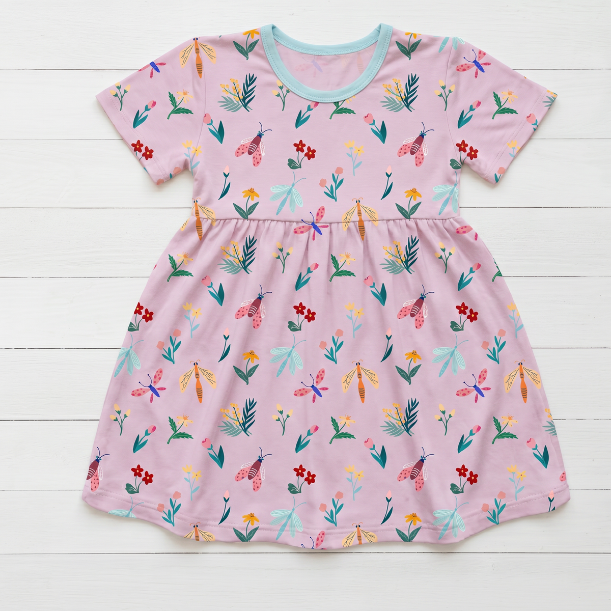 Short sleeve girls dress in a petal and bug print with a full twirl skirt