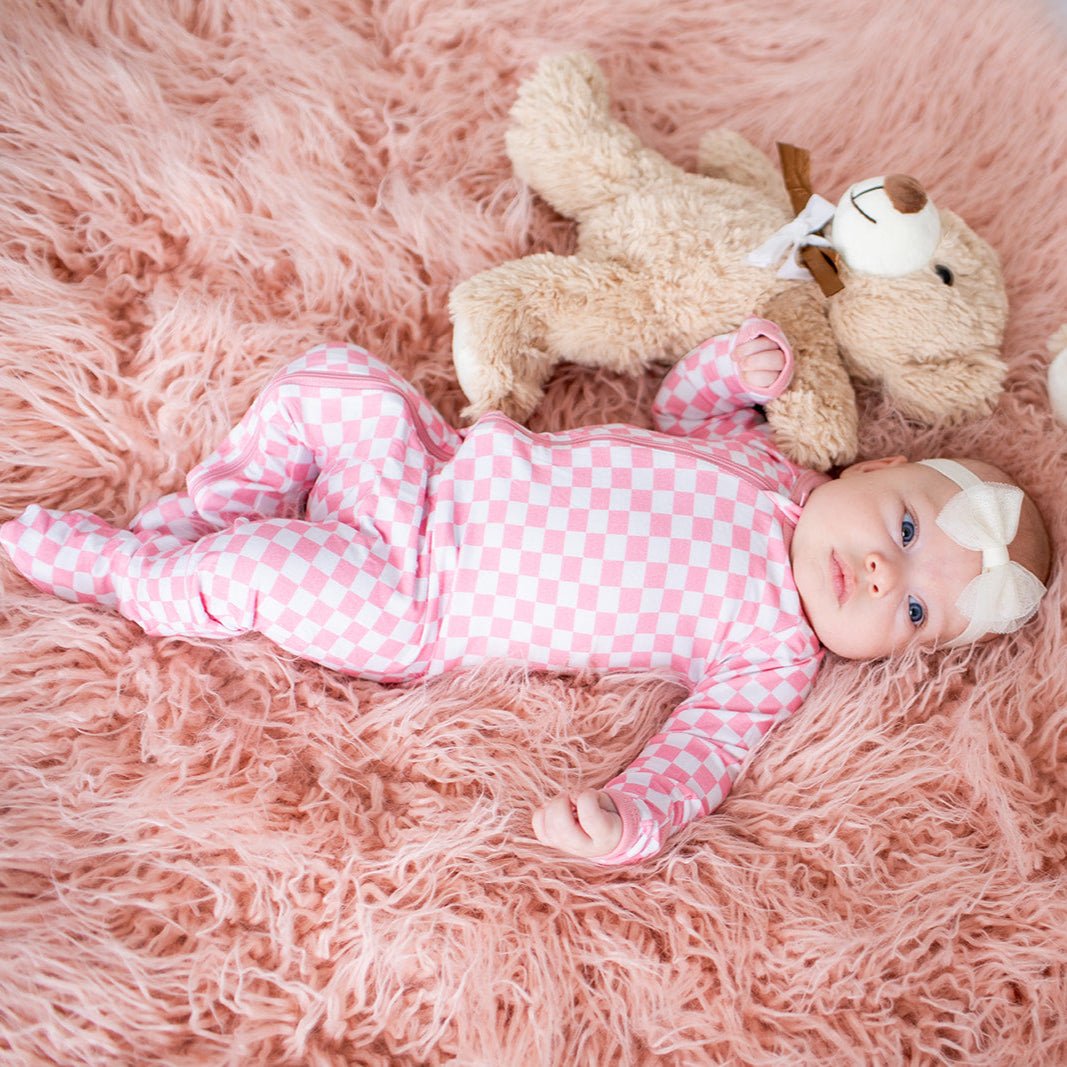 Footie pajamas in an all-over pink and white checkered print with fold-over mittens and a full-length zipper