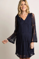 Navy maternity dress with sheer mesh overlay, short flutter sleeves, and a cinched waist.