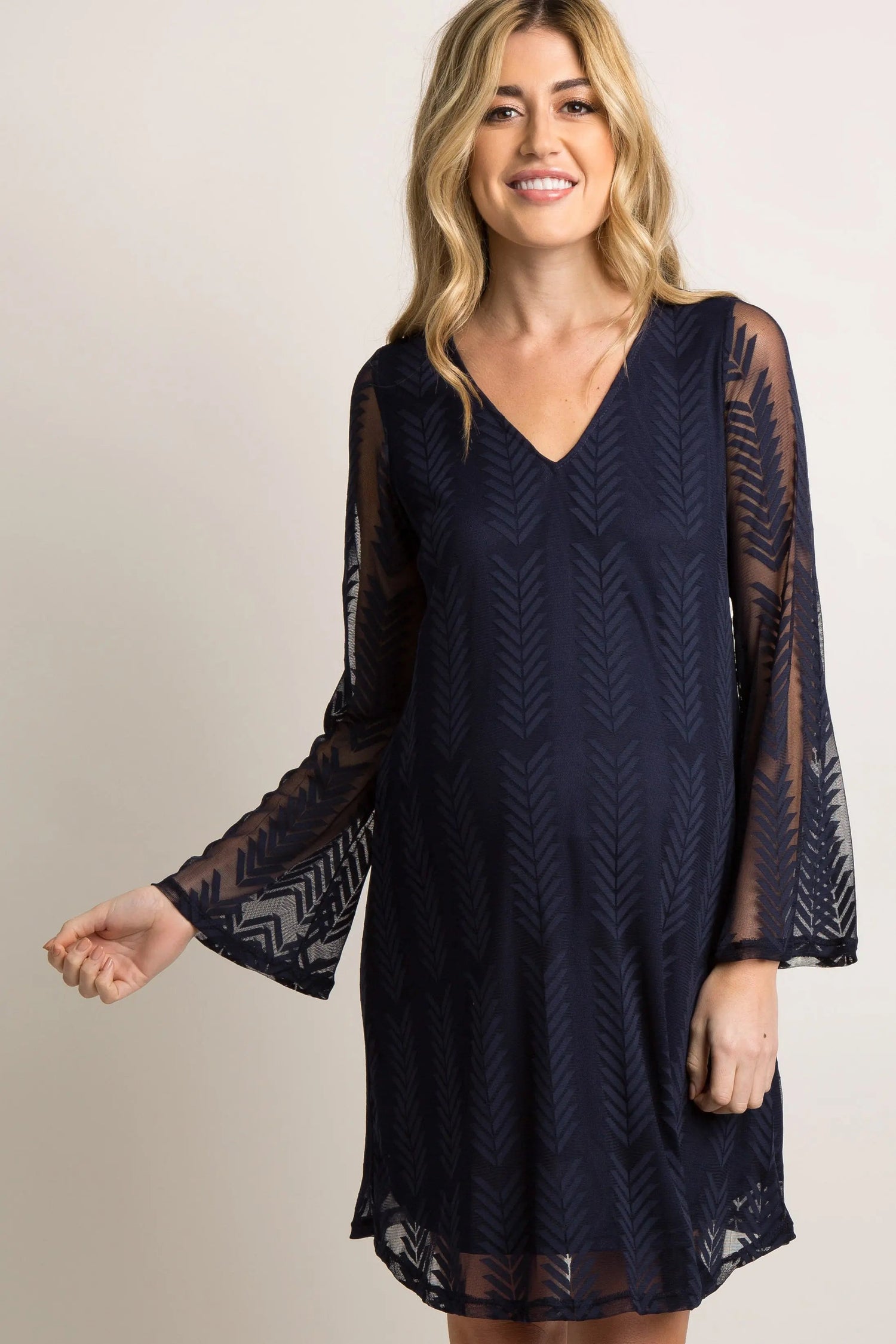 Navy maternity dress with sheer mesh overlay, short flutter sleeves, and a cinched waist.