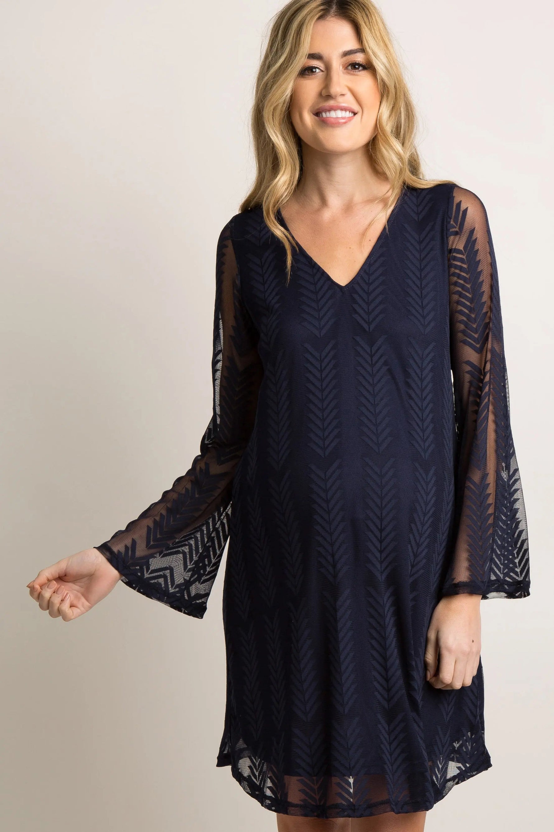 Navy maternity dress with sheer mesh overlay, short flutter sleeves, and a cinched waist.